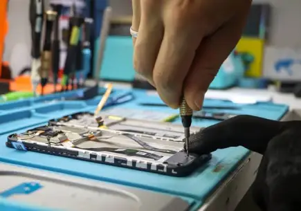 Expert technician repairing smartphone at a mobile repair center in Al Barsha Dubai